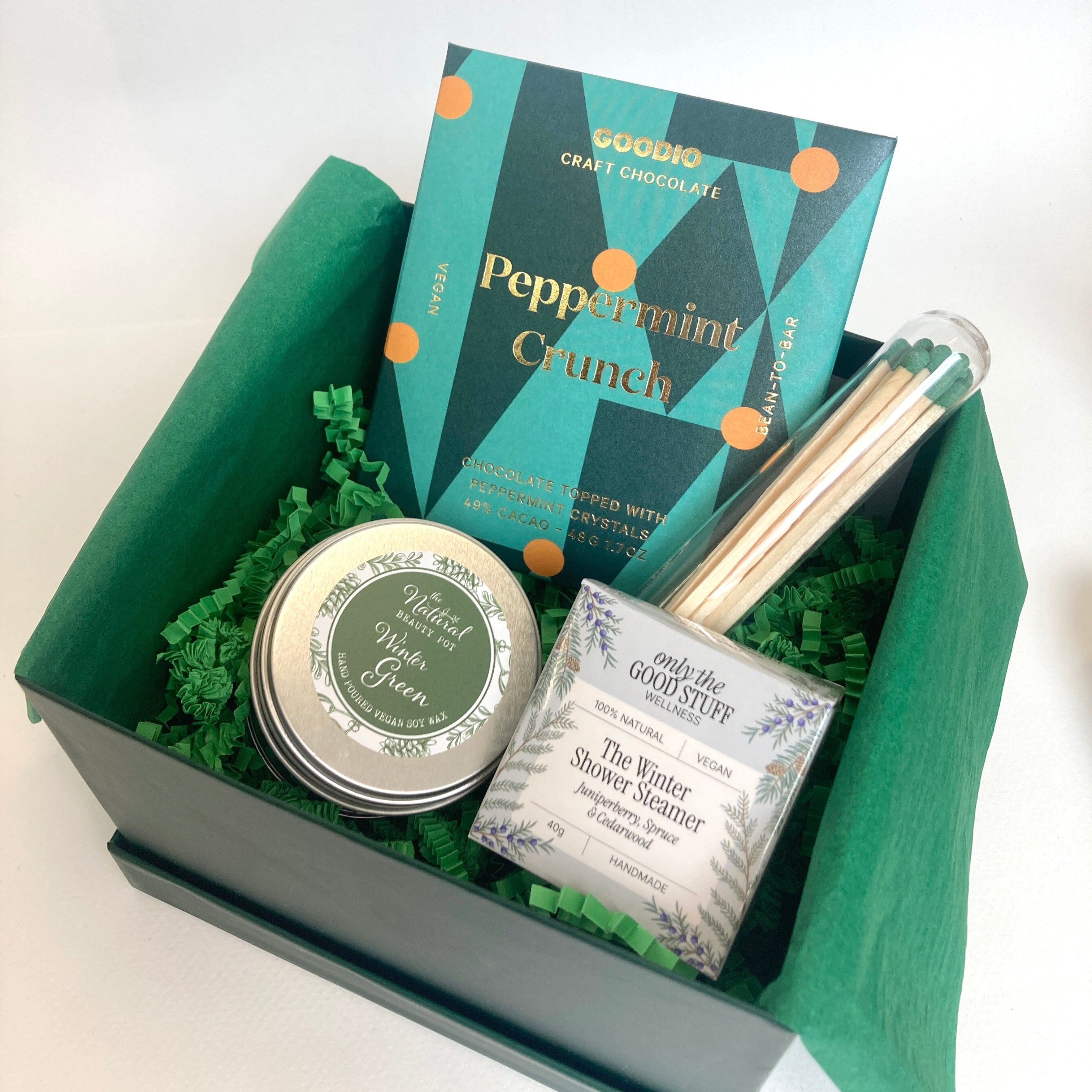 Gift set with peppermint crunch candy, a tin, and a box on a white background