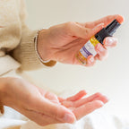 Person holding a small bottle of lavender facial oil for sensitive skin