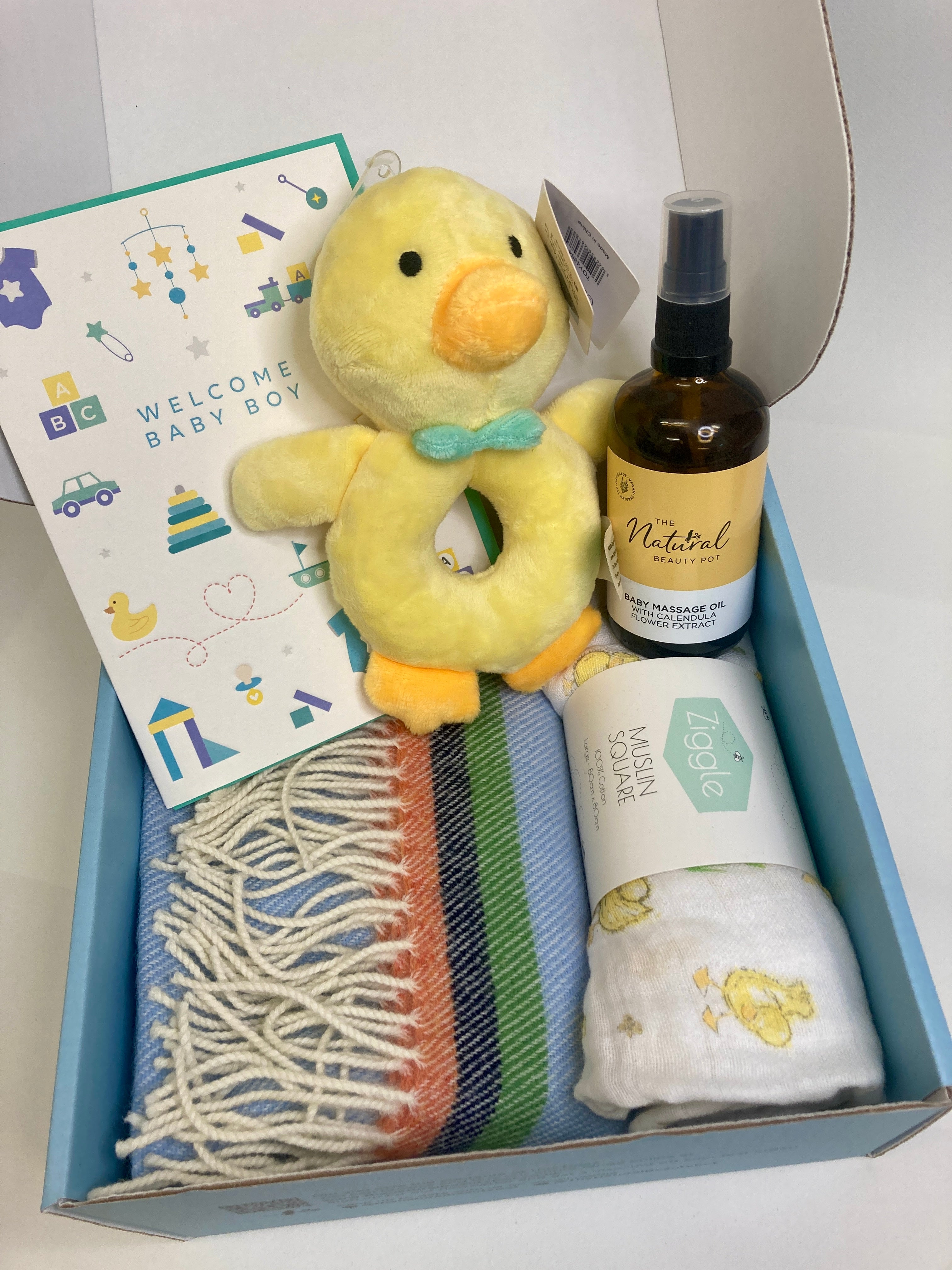 Baby boy gift box with natural and organic massage oil, plush duck, bottle, and blue Mcnutt blanket 