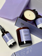 Set of 'Natural Beauty Pot.' lavender products including a body oil, a hand & body wash, and a candle in a  purple gift box.