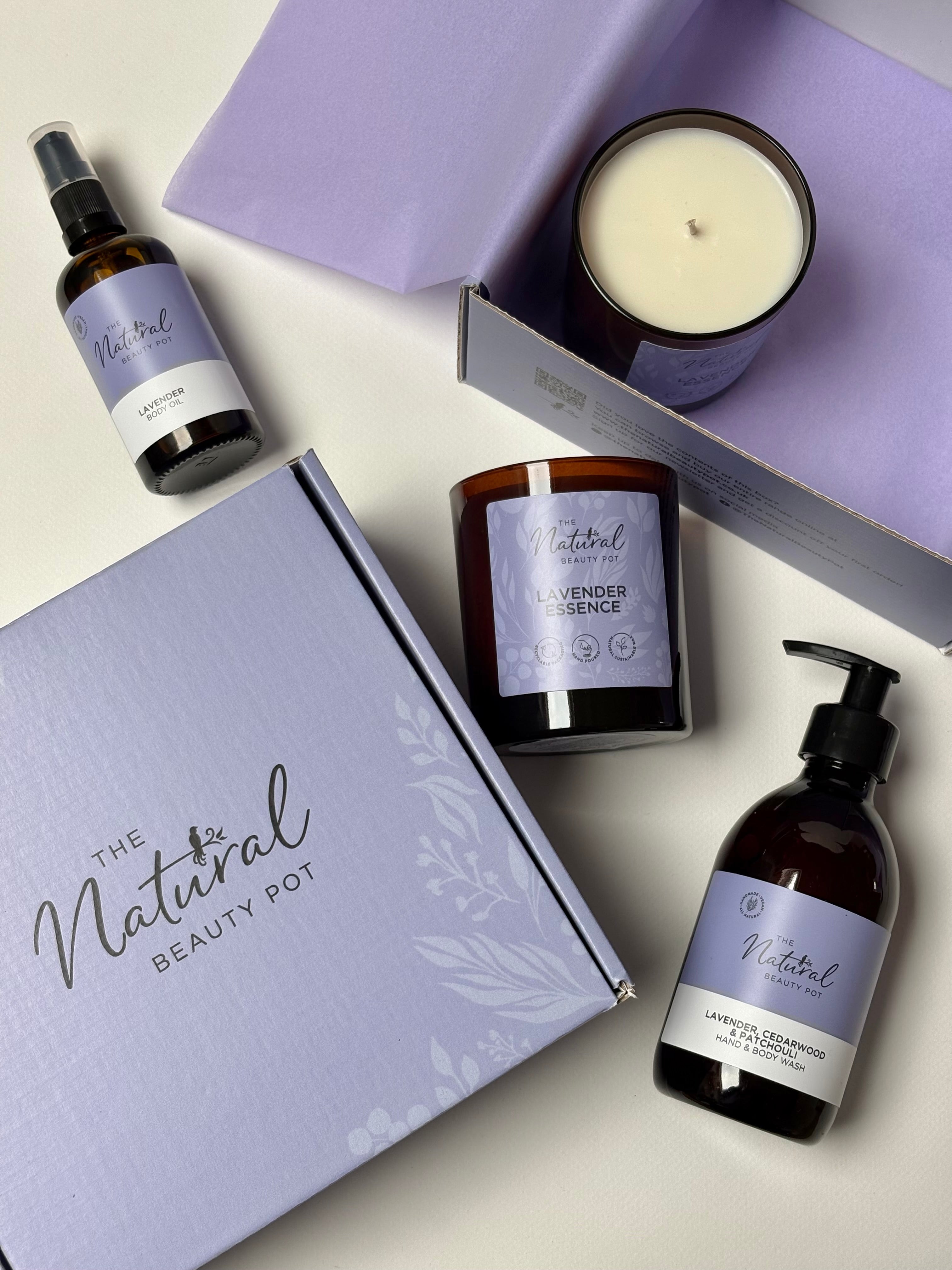 Collection of 'The Natural Beauty Pot' products including a natural hand wash, soy candle, and lavender body oil