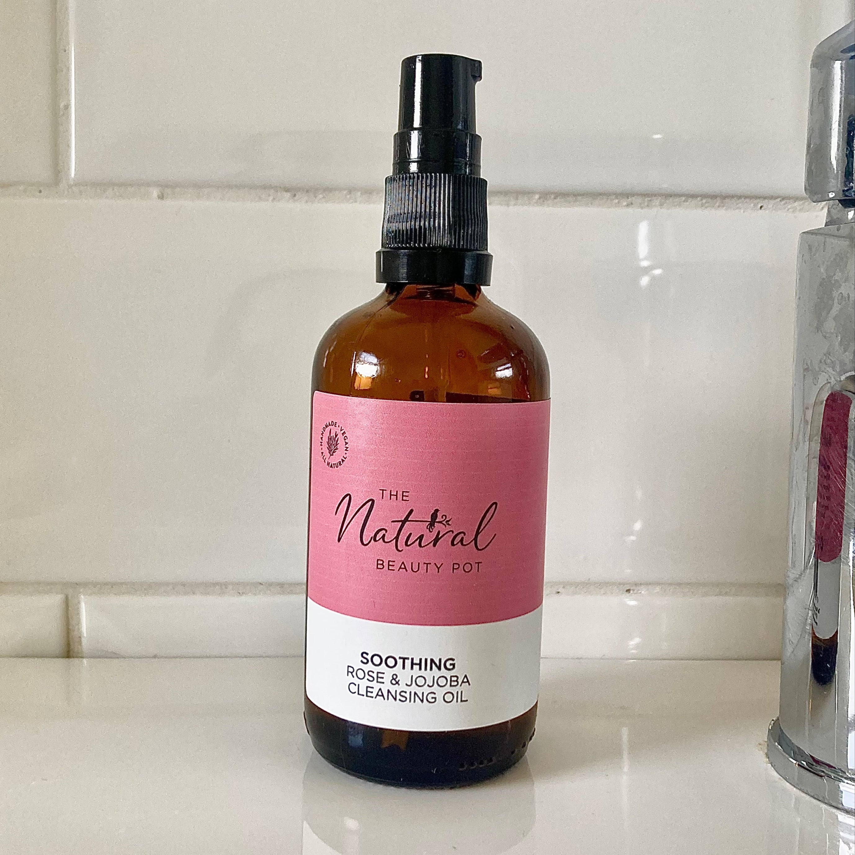 Bottle of 'The Natural Beauty Pot' cleansing oil on a kitchen counter.