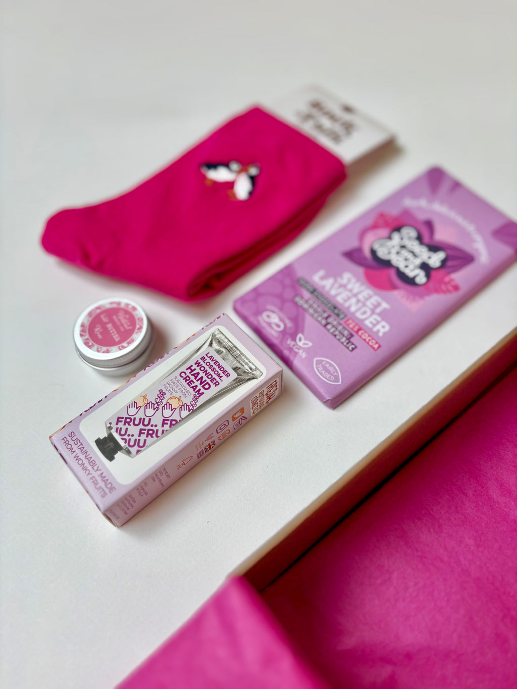 Pink socks and personal care products on a white surface