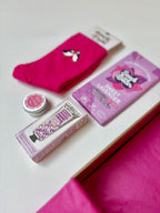 Pink socks and personal care products on a white surface