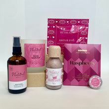 Collection of beauty products with pink packaging on a white background
