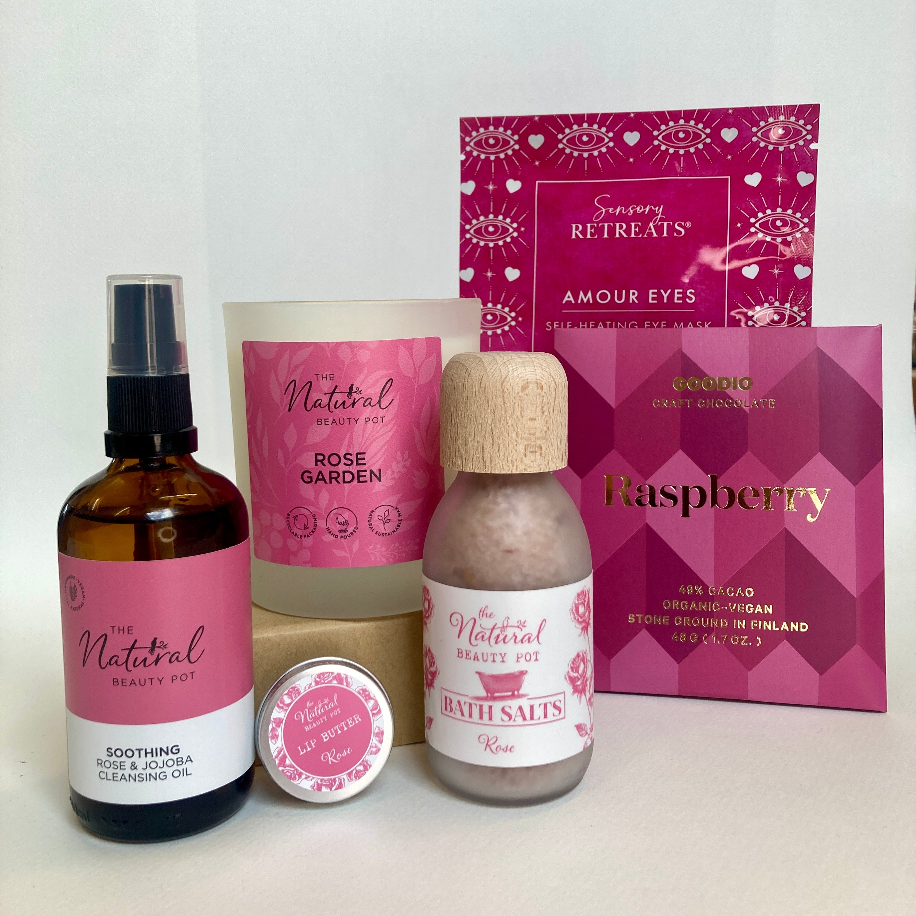 Collection of skincare products with pink and white packaging on a white background