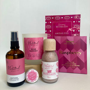 Collection of natural beauty products with pink packaging on a white background