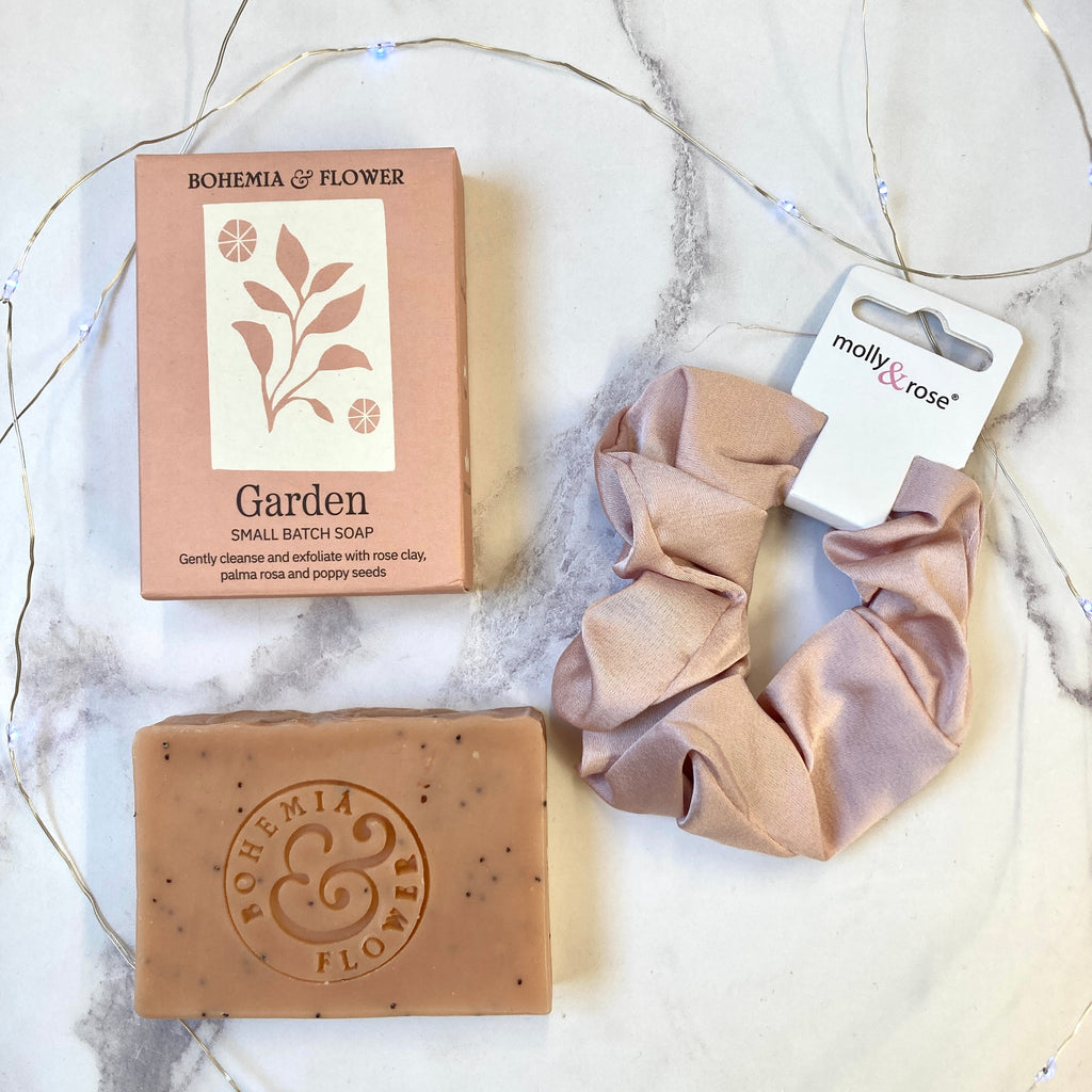 Bohemia & Flower soap bar and packaging with pink scrunchies on a marble surface.