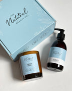 The Natural Beauty Pot gift set featuring a lavender & mint hand & body wash in an amber bottle and a 'Fresh Mint' scented candle in an amber glass jar, displayed next to their light blue branded gift box on a white background.