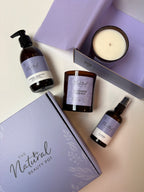 Collection of natural beauty products including soy candles and body oil and handwash in a luxury gift box from 'The Natural Beauty Pot' branding.