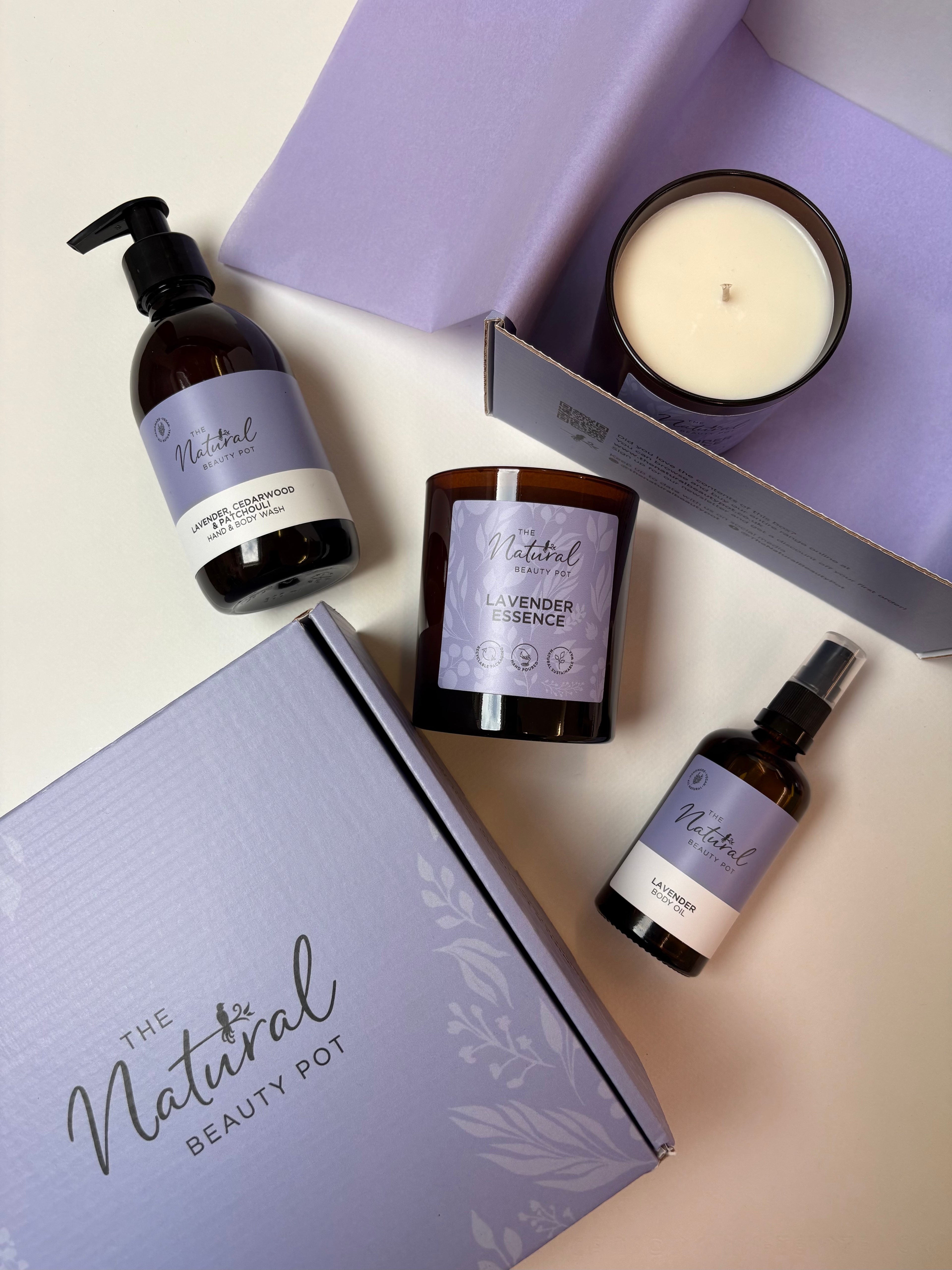 Collection of natural beauty products including soy candles and body oil and handwash in a luxury gift box from 'The Natural Beauty Pot' branding.