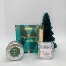 Collection of bath and body products including a candle, chocolate bar, and shower steamer on a white background.