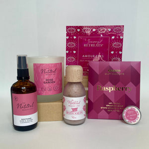 Collection of beauty products with pink and white packaging on a white background
