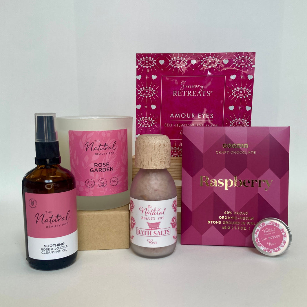 Collection of beauty products with pink and white packaging on a white background